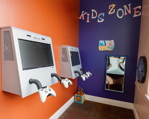 Child-friendly dental treatment room with colorful decor and Dr. Vafi providing gentle care to a young patient